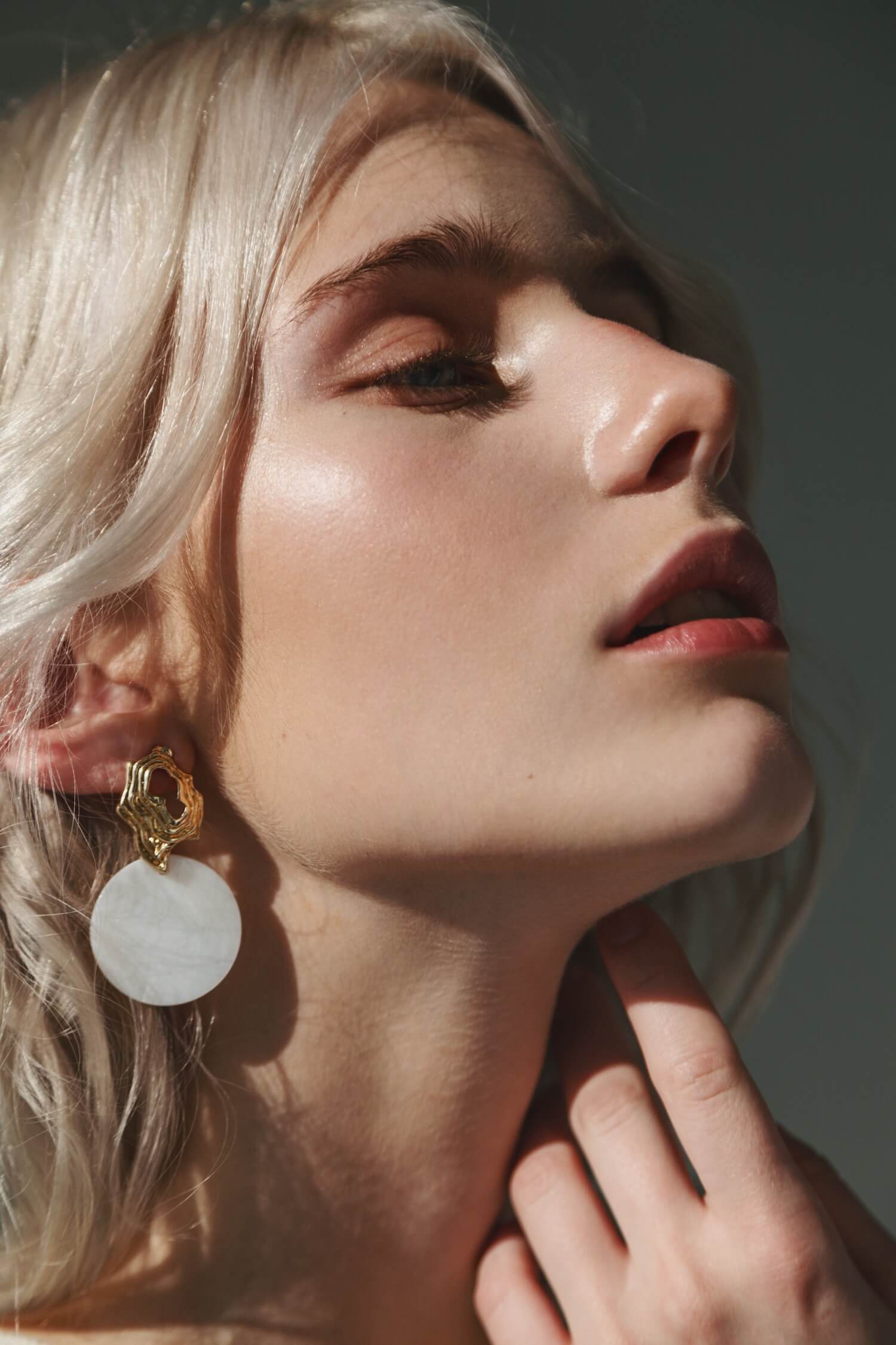 Image of a woman with blonde hair with white earings on