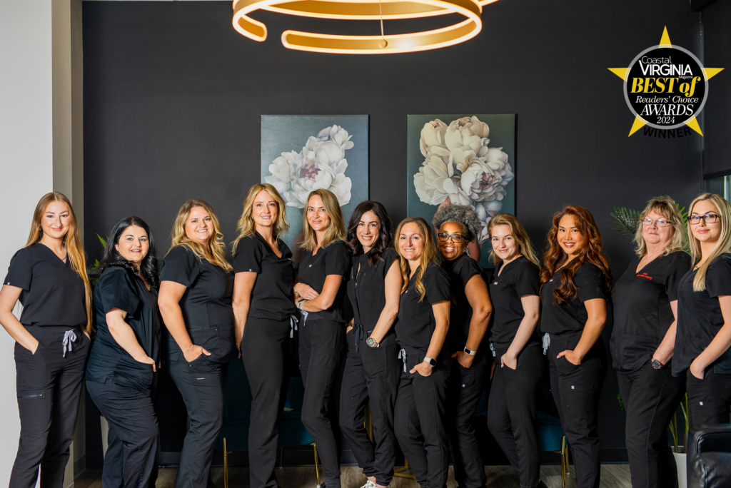 Staff of Galardi Bowen Plastic Surgery, dressed in black scrubs and smiling, celebrate winning an award for being a top cosmetic surgery center in the Hampton Roads area.