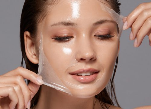 Photo of a woman peeling a chemical peel off of her face